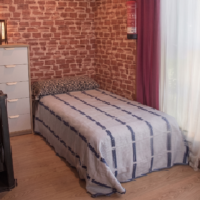 cama individual en salon de apartamento rural con jardin en llanes