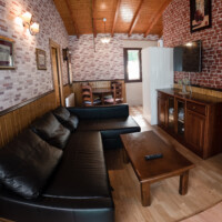 salon amplio de alquiler vacacional con chimenea y paredes de piedra en llanes