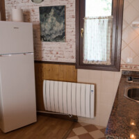 cocina americana con nevera y calefaccion en apartamento rural en asturias