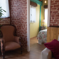 salon rustico con paredes de piedra y sillon clasico en apartamento vacacional